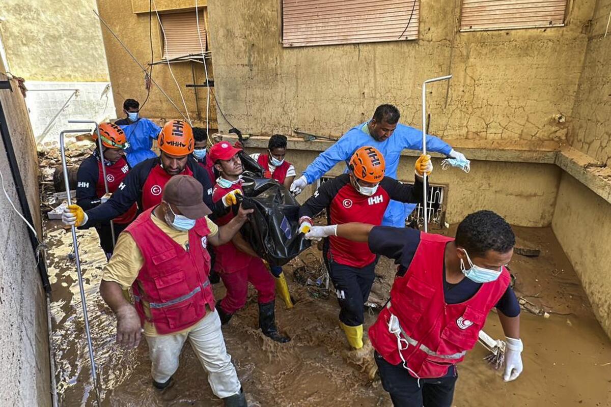 Rescuers carrying remains of a Libya flood victim