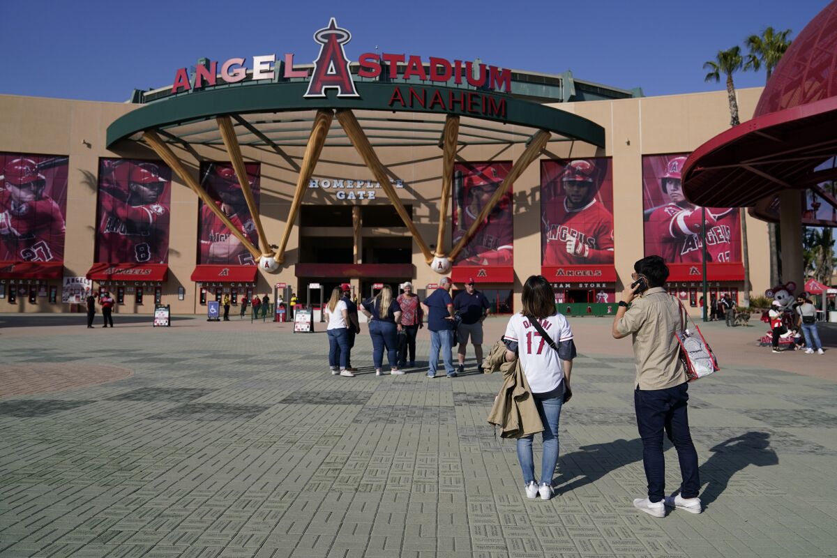 Fans stand outside the main entrance to Angel Stadium.