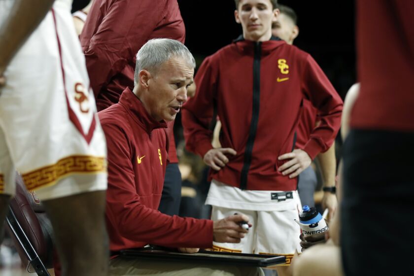Southern California head coach Andy Enfield, center, talks to his team during a timeout.