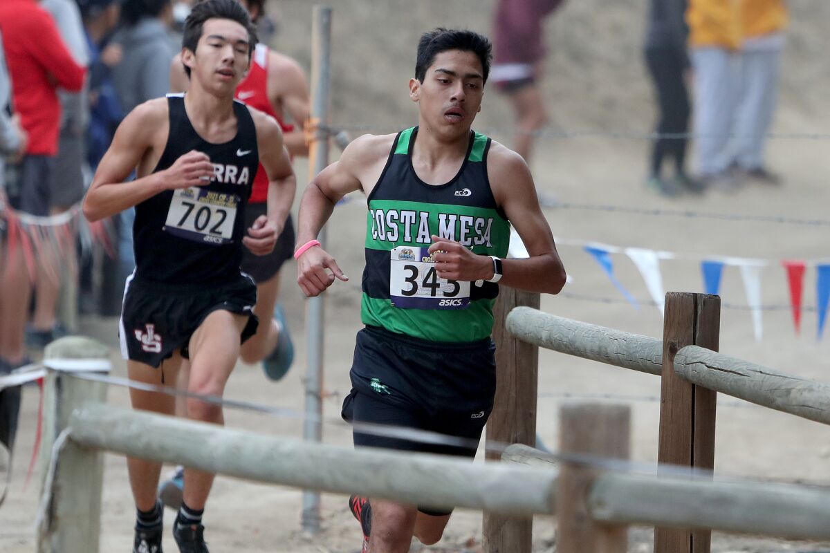 Costa Mesa senior Edward Rodriguez, right, places 17th in the Division 4 boys' race.