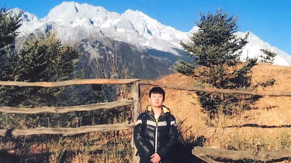 An undated picture released by his family shows Yu Huan at an unknown location. He attacked the thugs who tormented his mother, killing one of them.