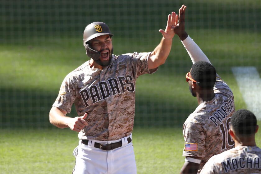 San Diego Padres' Eric Hosmer celebrates with Jurickson Profar after scoring on a double by Tommy Pham in the 