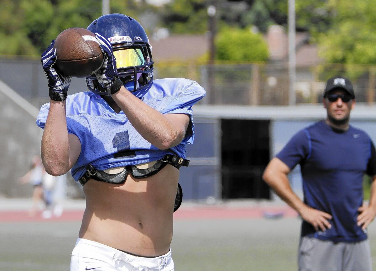 Crescenta Valley High School football player #1 Chase Walker catches the ball during drills at the La Crescenta school's football field on Tuesday, Aug. 19, 2014.