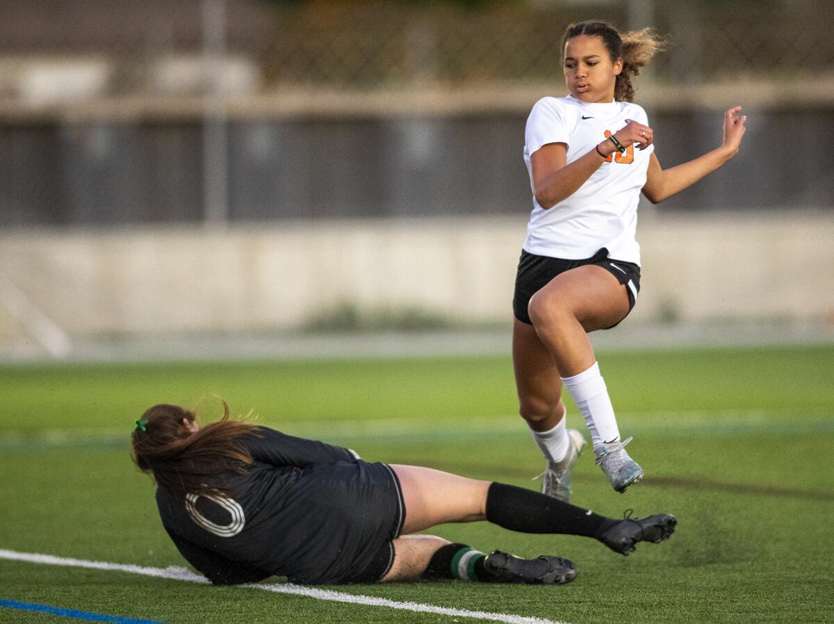 Huntington Beach's Jaiden Anderson leaps over Edison's Allyssa Plotkin after she saved a shot on goal on Wednesday.