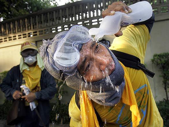 Protest in Thailand - demonstrator washes tear gas