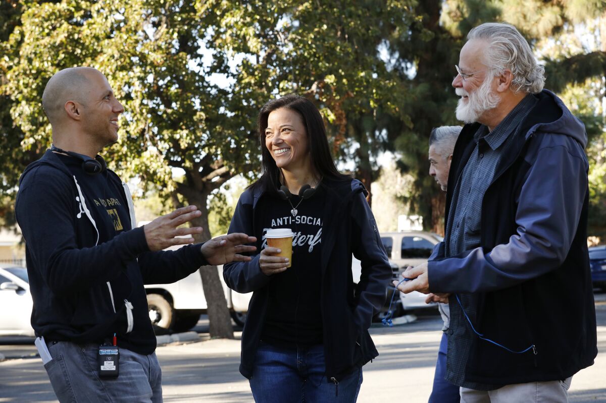 Author Michael Connelly, right, with LAPD Det. Mitzi Roberts, middle, and Tom Bernardo, supervising producer and writer, left, on the set shooting of "Bosch" Season 5 in the San Fernando Valley.