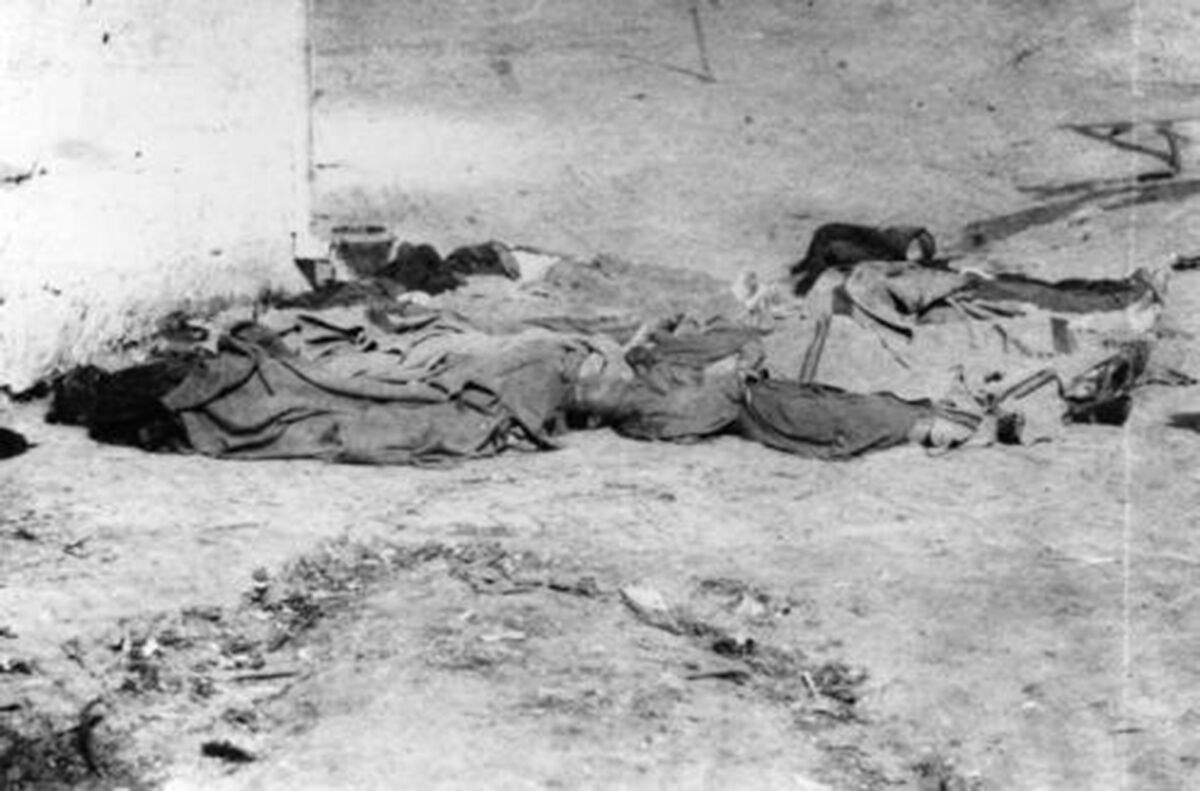 A black and white photo of covered bodies