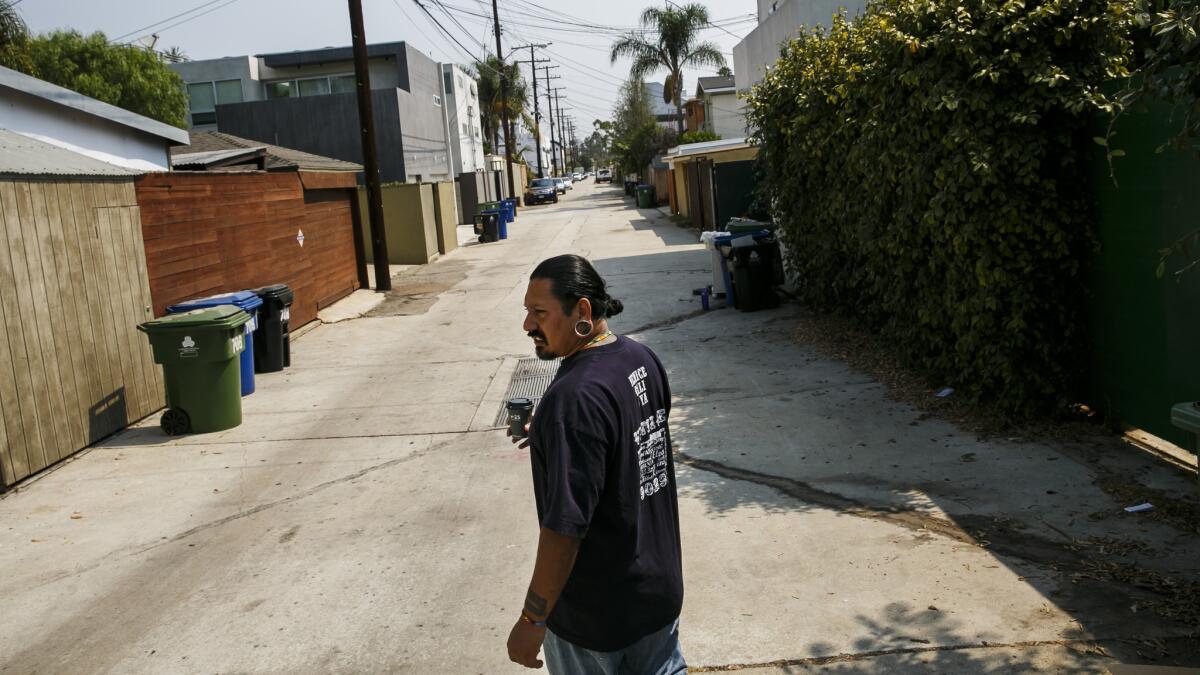 Venice native Mike Bravo walks through an alley in Venice's Oakwood neighborhood.