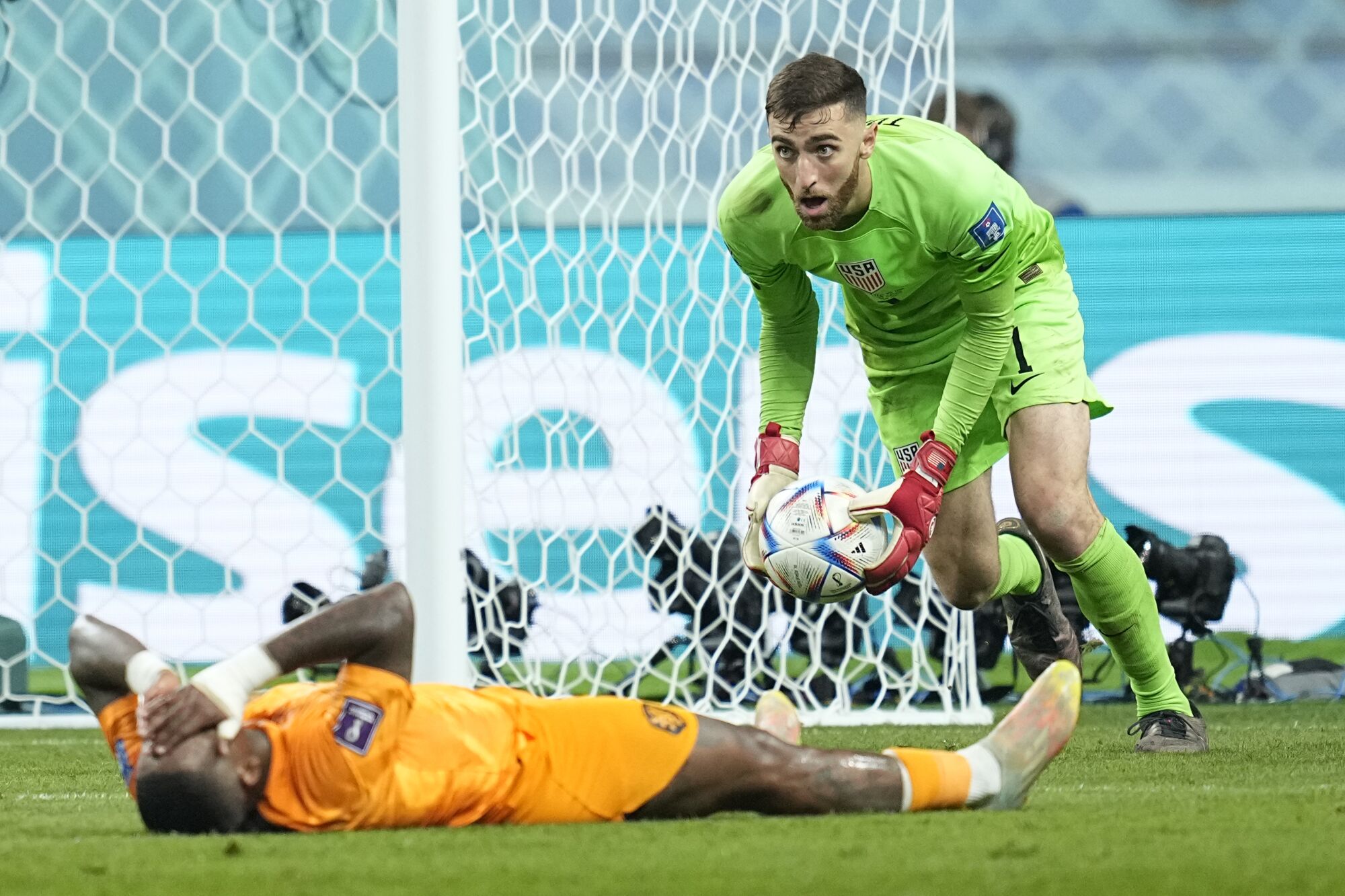 U.S. goalkeeper Matt Turner collects the ball as the Netherland's Steven Bergwijn covers his face after failing to score 