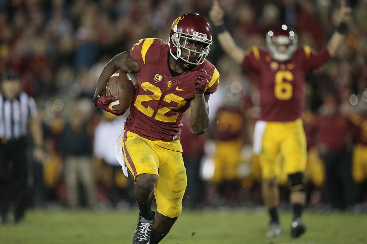 USC running back Justin Davis rushes to the end zone as quarterback Cody Kessler signals touchdown in the fourth quarter of the Trojans' 38-30 victory over the Wildcats last Satuday.
