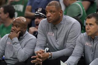 Philadelphia 76ers head coach Doc Rivers, center, watches from the bench