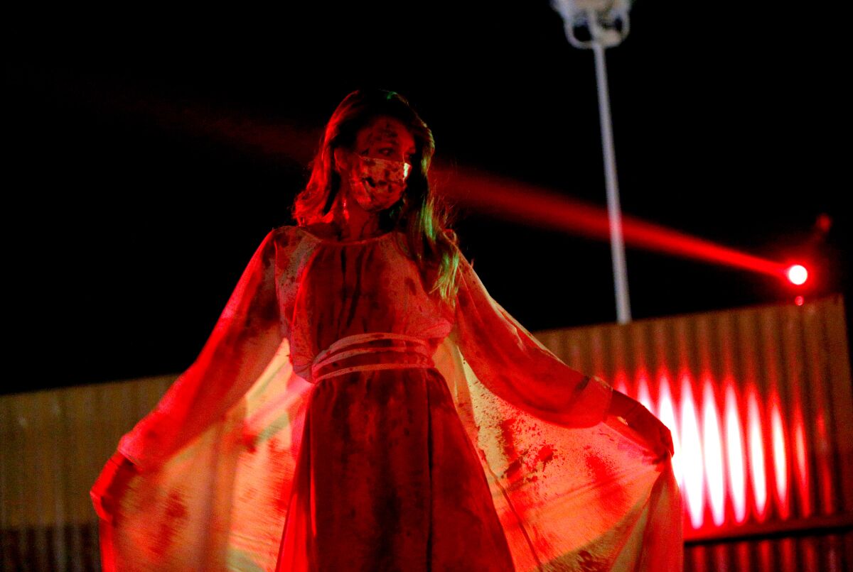 A bloody actor strikes a pose as cars pass by during a 45-minute, drive-through Urban Legends Haunt at the O.C. fairgrounds.
