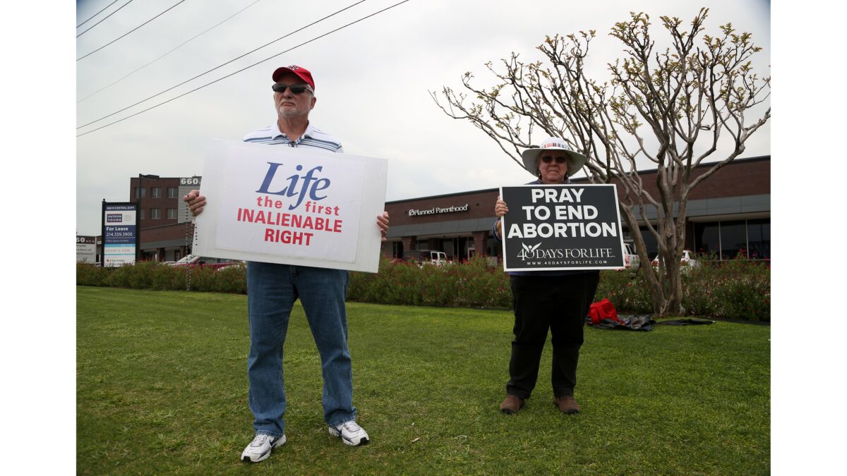 Charlie Kain and Mary Borchard, with the 40 Days for Life group, protest in front of a Planned Parenthood health center in Plano, Texas.