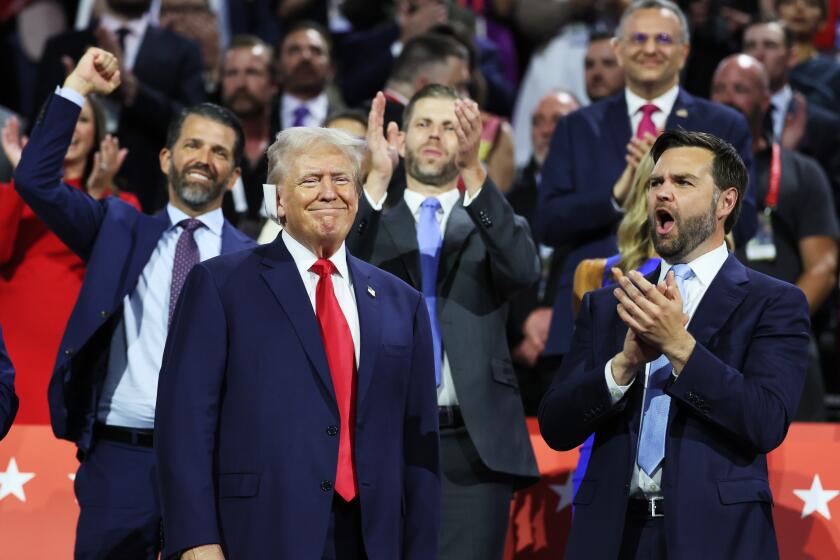 MILWAUKEE, WI JULY 15, 2024 -- Surrounded by family, Donald Trump Jr., Eric Trump and Republican vice presidential candidate Sen. JD Vance cheer former US President Donald Trump during the first day of the Republican National Convention at Milwaukee, WI on Monday, July 15, 2024. (Robert Gauthier / Los Angeles Times)