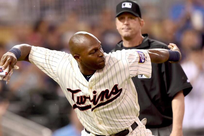 Umpire Jeff Kellogg watches as Twin outfielder Torii Hunter throws his batting glove onto the field after getting ejected from a game against the Kansas City Royals on June 10.