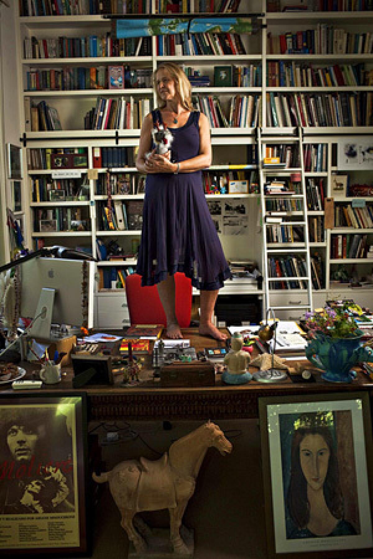 Cornelia Funke, best-selling author of the "Inkheart" series, at her Beverly Hills home -- on top of her desk with a stuffed dragon.