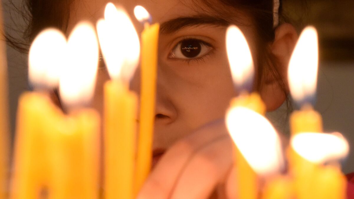 A girl places a candle at the cathedral in Etchmiadzin, Armenia, outside Yerevan, ahead of a ceremony marking the Armenian genocide.