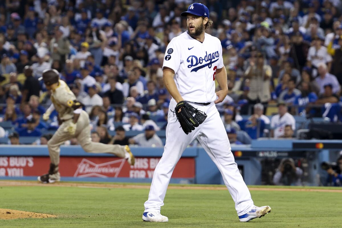 Dodgers starting pitcher Clayton Kershaw looks back after allowing an RBI double to San Diego Padres' Manny Machado.