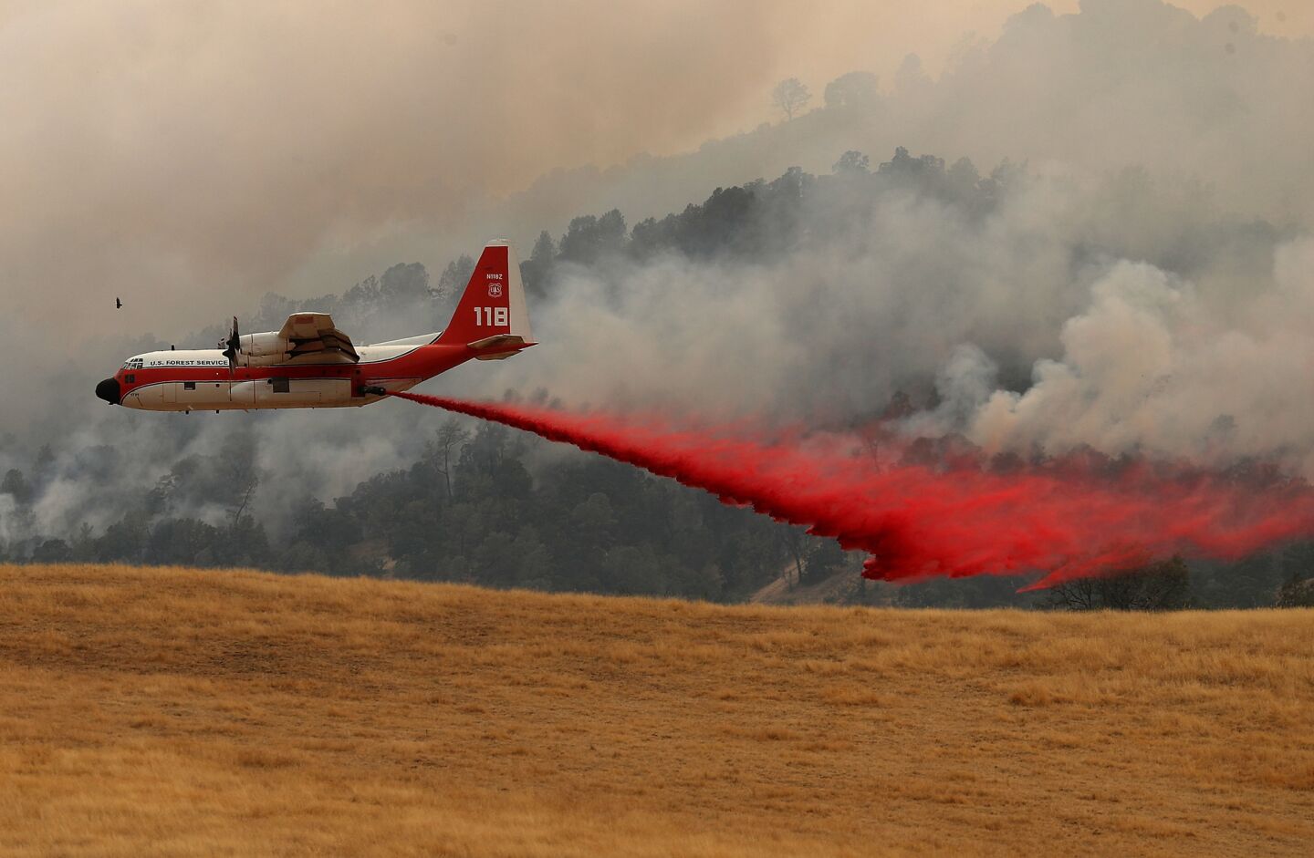 A firefighting air tanker drops fire retardant on a hillside ahead of the County Fire Monday in Esparto, California.