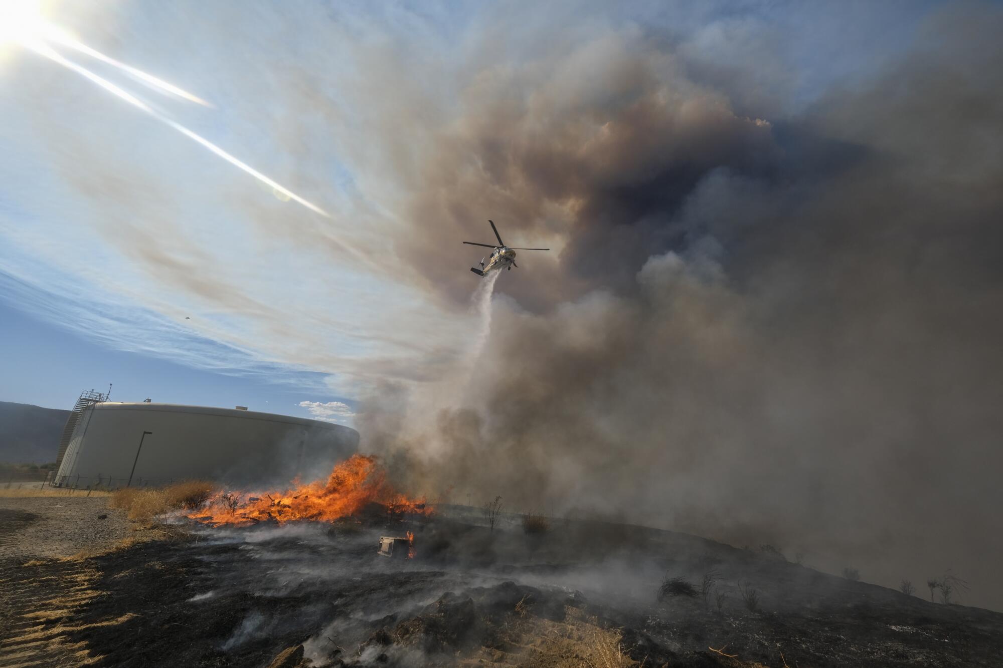A helicopter drops water on the Route fire near Castaic.