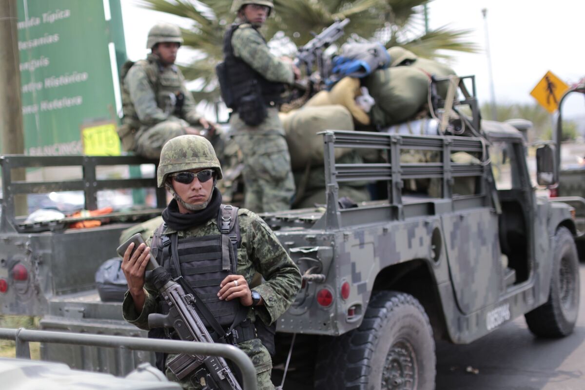 Mexican soldiers stand guard outside Chilapa in the state of Guerrero, a combat zone for drug gangs, in May 2015.