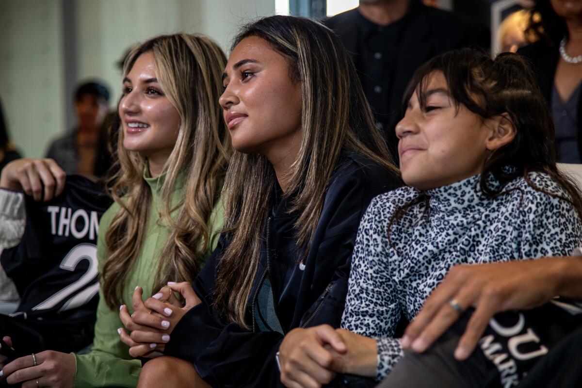 Seated between her two sisters, Gisele, left, and Zoe, Alyssa Thompson waits before being drafted.