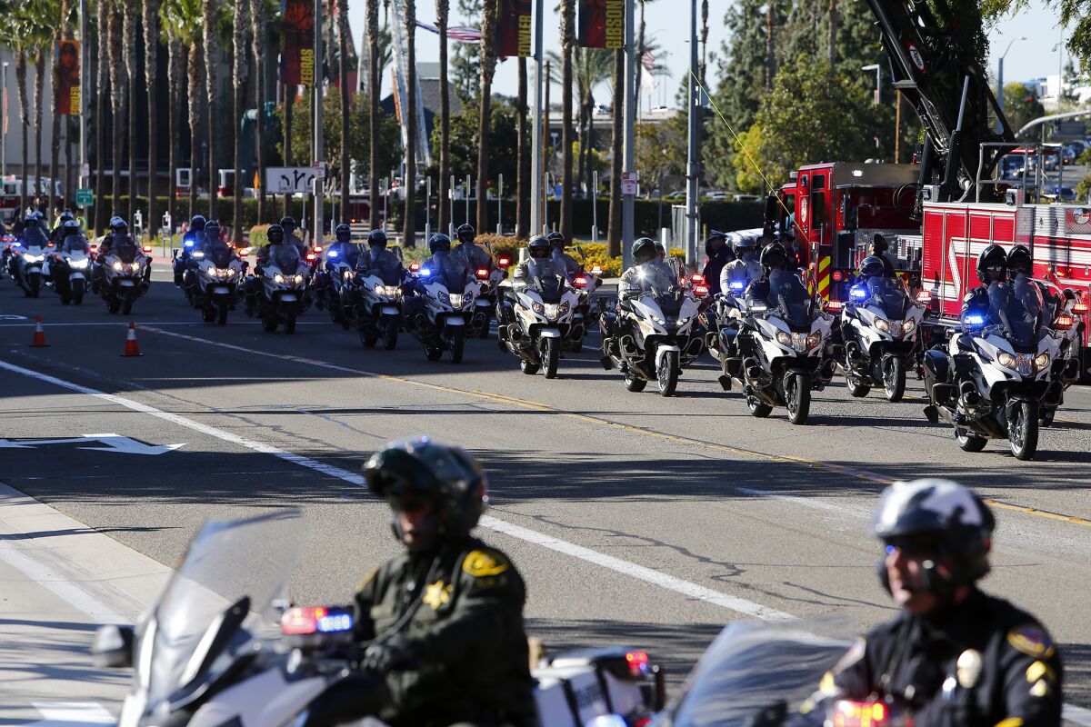 Orange County Sheriff motorcycle officers arrive for Nicholas Vella's memorial on Tuesday morning at the Honda Center.