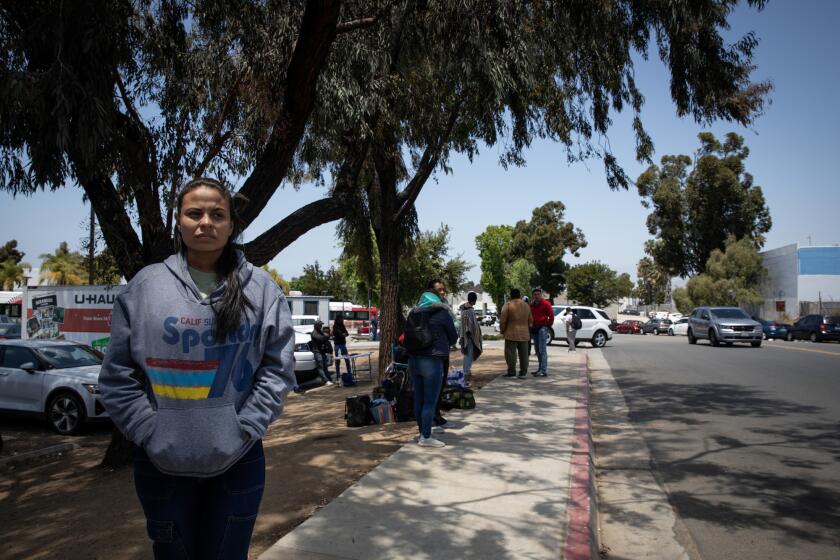 San Diego, California - May 16: Jormary, of Colombia, and about a dozen other migrants wait at the Iris Avenue Transit Center on Thursday, May 16, 2024 in San Diego, California. Many have been waiting for days. They travel back and forth from the station to the airport waiting to be picked up or given more information about where to seek shelter. (Ana Ramirez / The San Diego Union-Tribune)