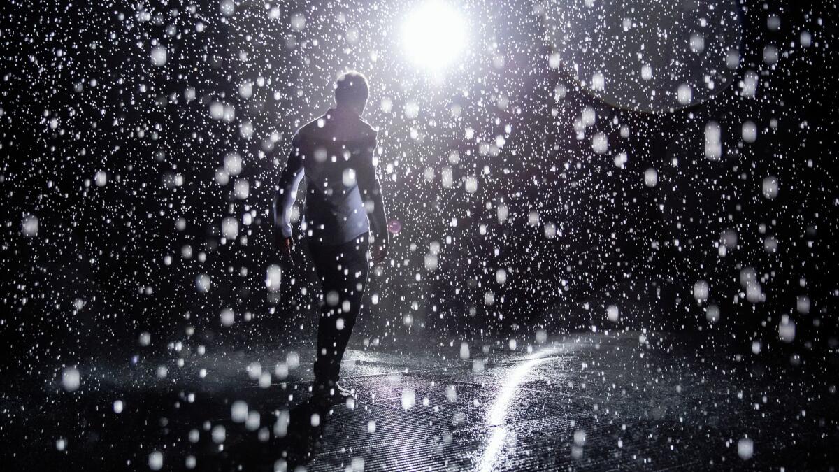 Random International's Hannes Koch test out the sensitivity of the sensors inside the Rain Room, on exhibit at LACMA in Los Angeles, Calif., on Oct. 26, 2015.