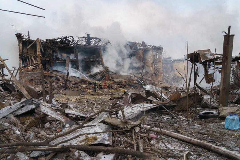 TOPSHOT - Firefighters spray water on a destroyed shoe factory following an airstrike in Dnipro on March 11, 2022. - Civilian targets came under Russian shelling in the central Ukrainian city of Dnipro on March 11, killing one, emergency services said, in what appeared to be the first direct attack on the city. (Photo by Emre CAYLAK / AFP) (Photo by EMRE CAYLAK/AFP via Getty Images)