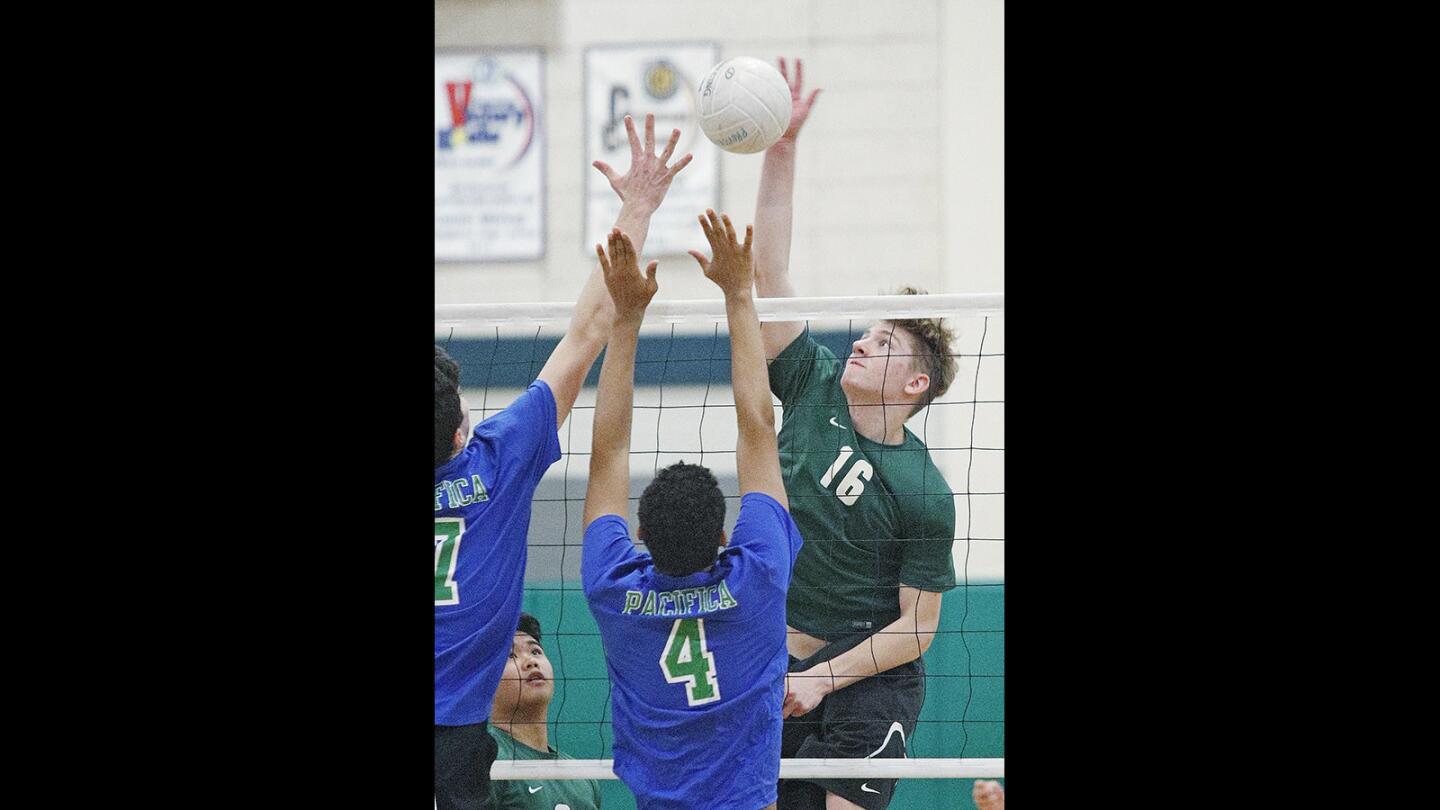 Providence's Carl Menke hits a kill against Pacifica's Timmy Ellis and Kyle Cropperin a Liberty League boys' volleyball match at Providence High School on Wednesday, April 11, 2018. Providence won the match 3-0.