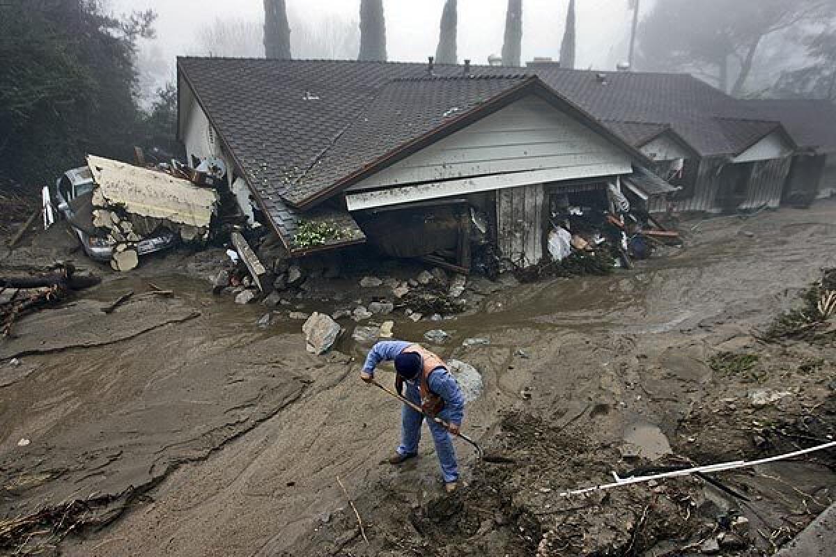 A gas company worker digs in front of a heavily damaged home on Manistee Drive, where the February 2010 mudslide caused a gas leak.