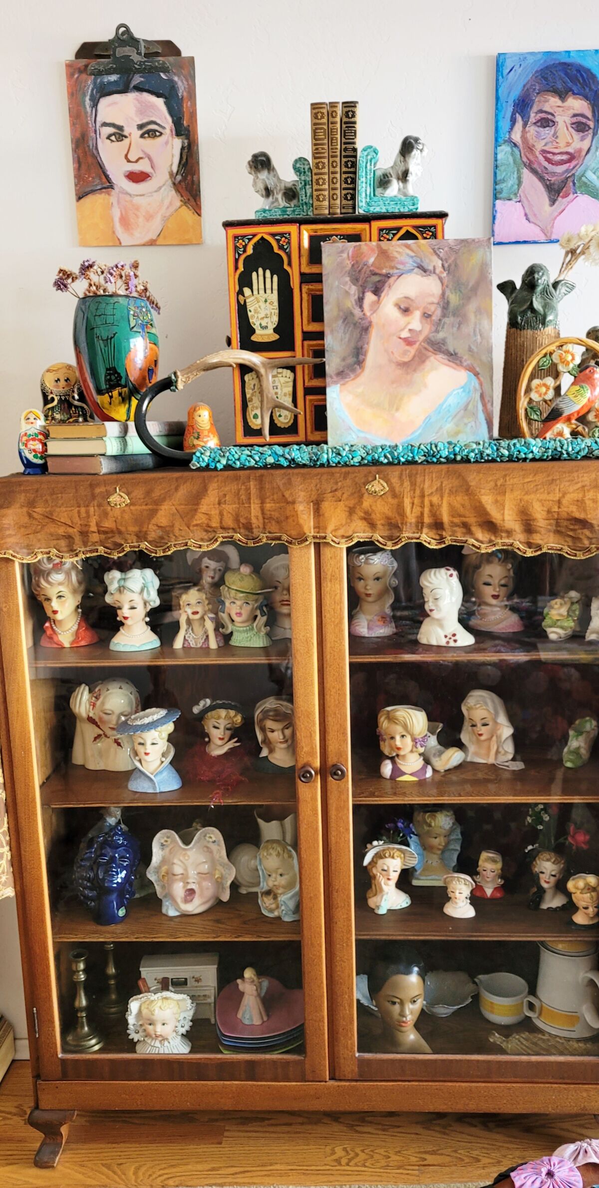 An antique cabinet showcases Sheree Perelman’s collection of lady head vases.