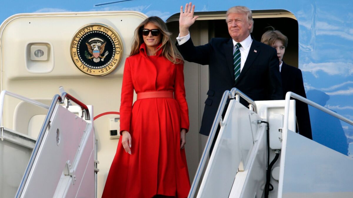 President Trump waves from Air Force One with First Lady Melania Trump and son Barron after arriving at the Palm Beach International Airport on Friday for a weekend at his Mar-a-Lago resort.