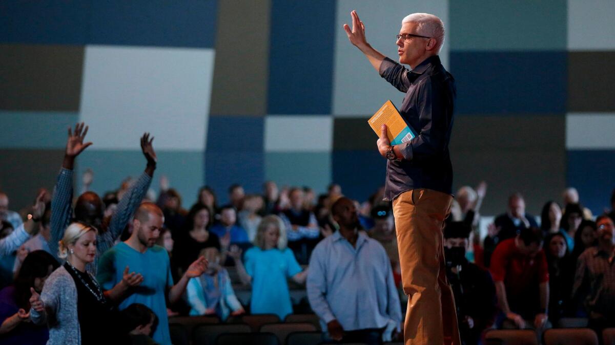 Pastor David Daniels prays with the congregation at the conclusion of a service at Pantego Bible Church in Fort Worth.