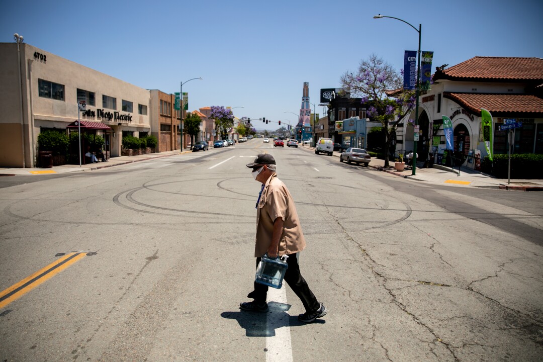 Ron Dobbins, 75, who lives about a block away from the number 7 bus stop, carries water back to his home.