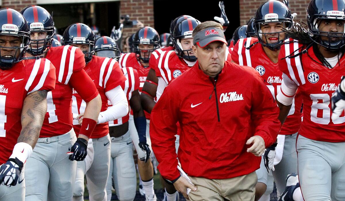 Mississippi Coach Hugh Freeze leads the Rebels onto the field for a game against Louisiana State.