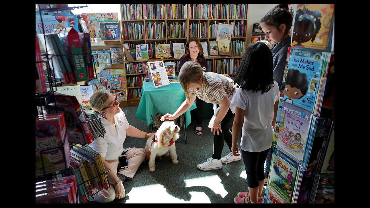 Children got a chance to pet Lending a Paw therapy dog "Ernie" before Brenda Scott Royce, rear center, read her book "Champion's New Shoes" at the Flintridge Bookstore & Coffeehouse on Independent Bookstore Day, in La CaÃ±ada Flintridge on Saturday, April 28, 2018.