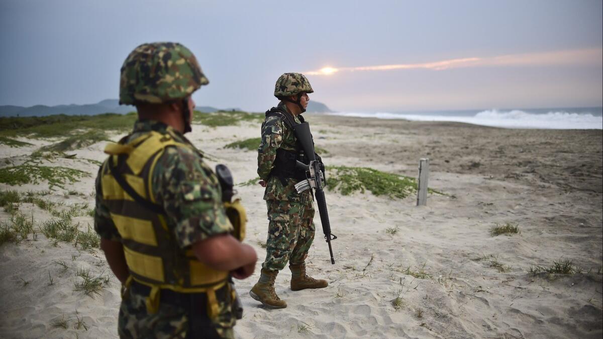 Mexican marines stand guard, protecting the olive ridley sea turtles from egg thieves as they spawn at Morro Ayuta Beach in Oaxaca state.