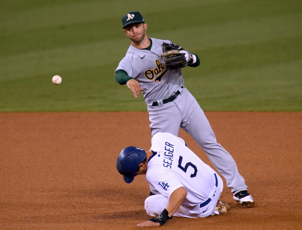 Tommy La Stella #3 of the Oakland Athletics attempts a throw over Corey Seager.