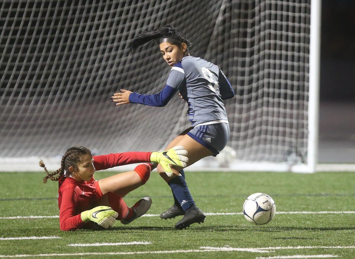 Los Alamitos High goalkeeper Reezyn Turk, left, fights off a shot by Newport Harbor's Skylynn Rodriquez in the quarterfinals of the CIF Southern Section Division 1 playoffs on Tuesday.