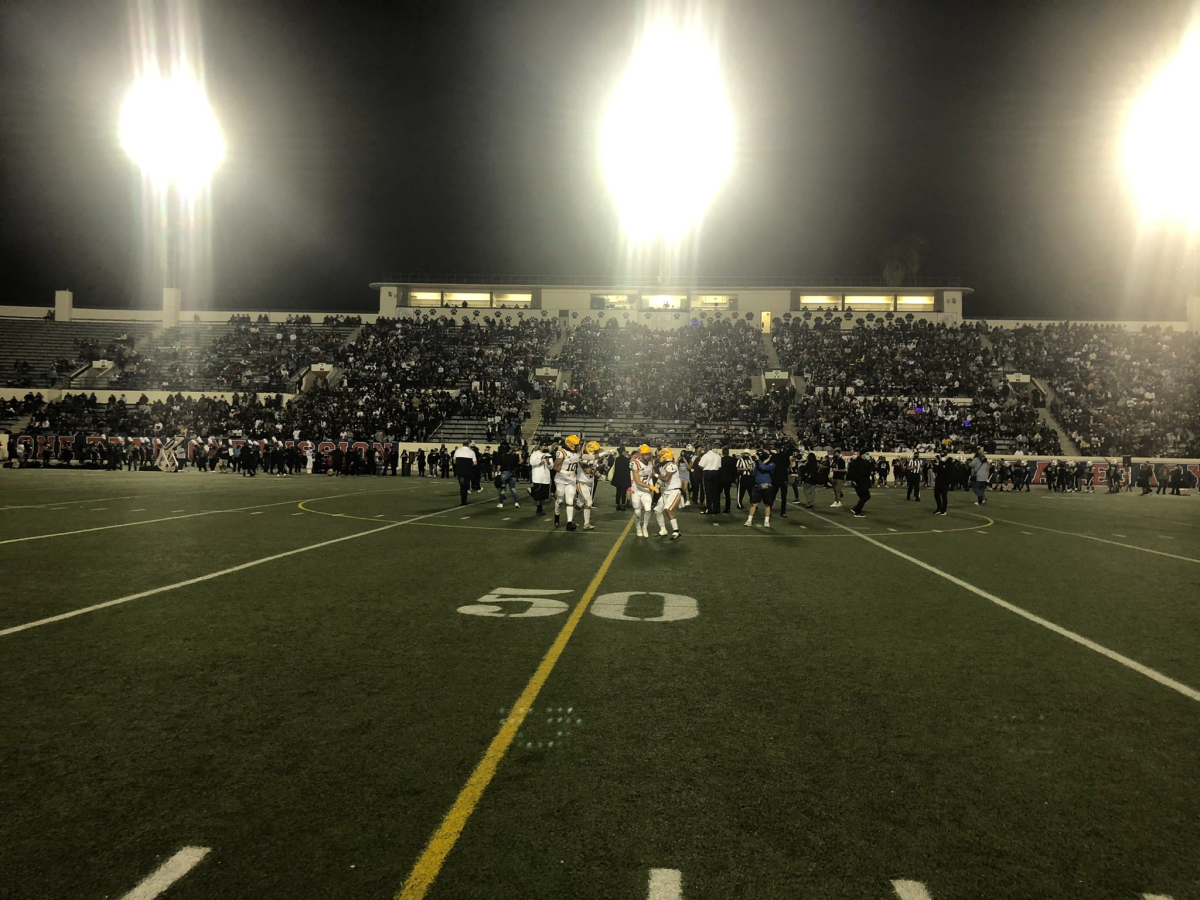 Players for Roosevelt and Garfield meet at midfield before the start of the 2021 East L.A. Classic.