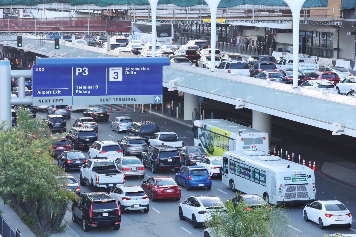 Stopped vehicles line an airport roadway's upper level