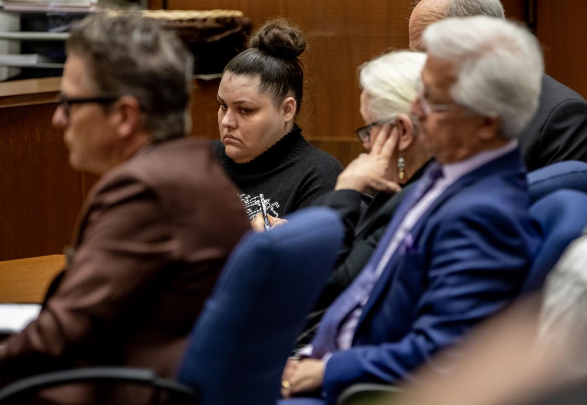 Heather Barron sits in a court room among lawyers. 