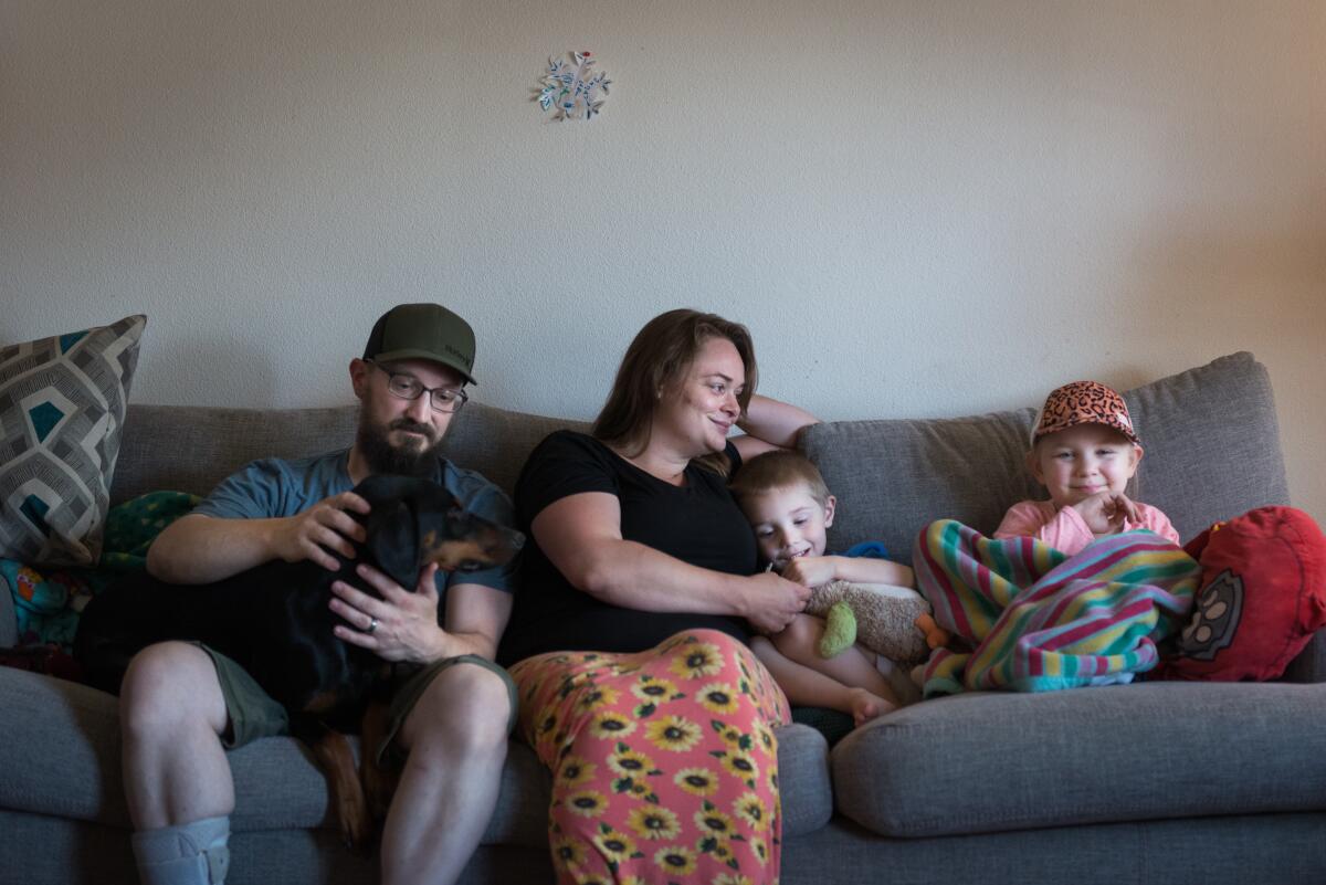 The Lewis family — from left, Spencer, Deborah, Owen, and Annabelle — hang out with their dog.
