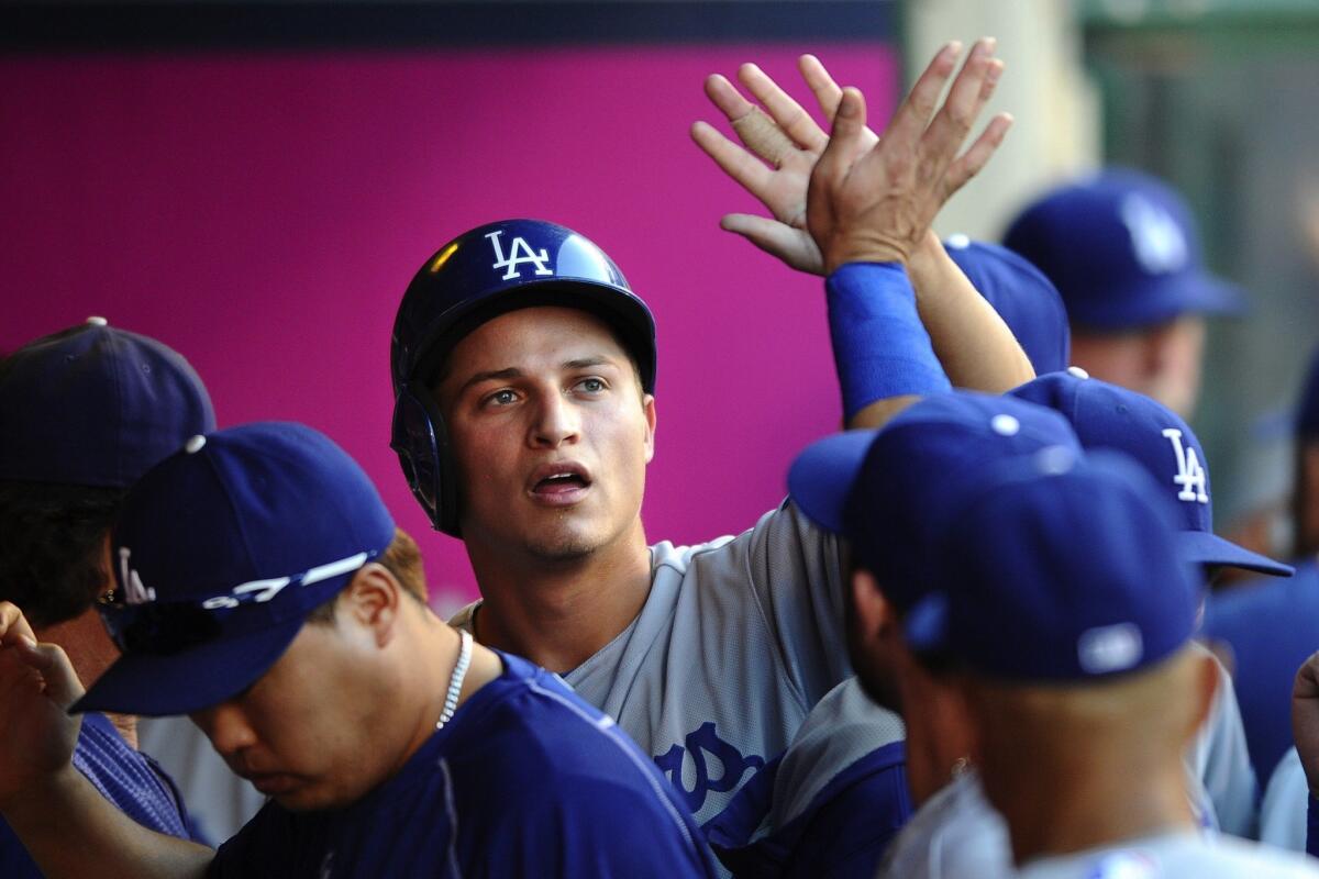 Corey Seager is congratulated by his Dodger teammates after scoring a run against the Angels at Angel Stadium on Sept. 7