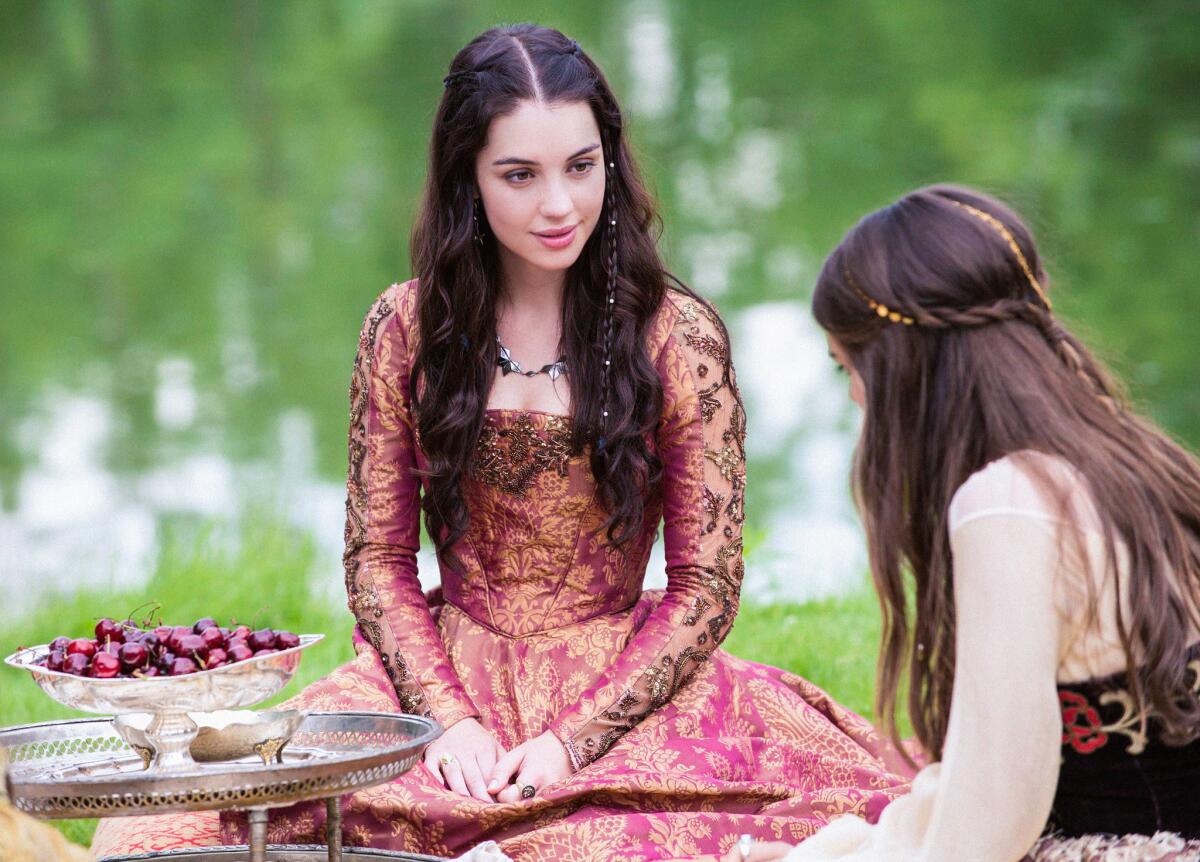 This image released by The CW shows Adelaide Kane as Mary, Queen of Scots, left, and Caitlin Stasey as Kenna in a scene from the new series "Reign," premiering Thursday, Oct. 17.