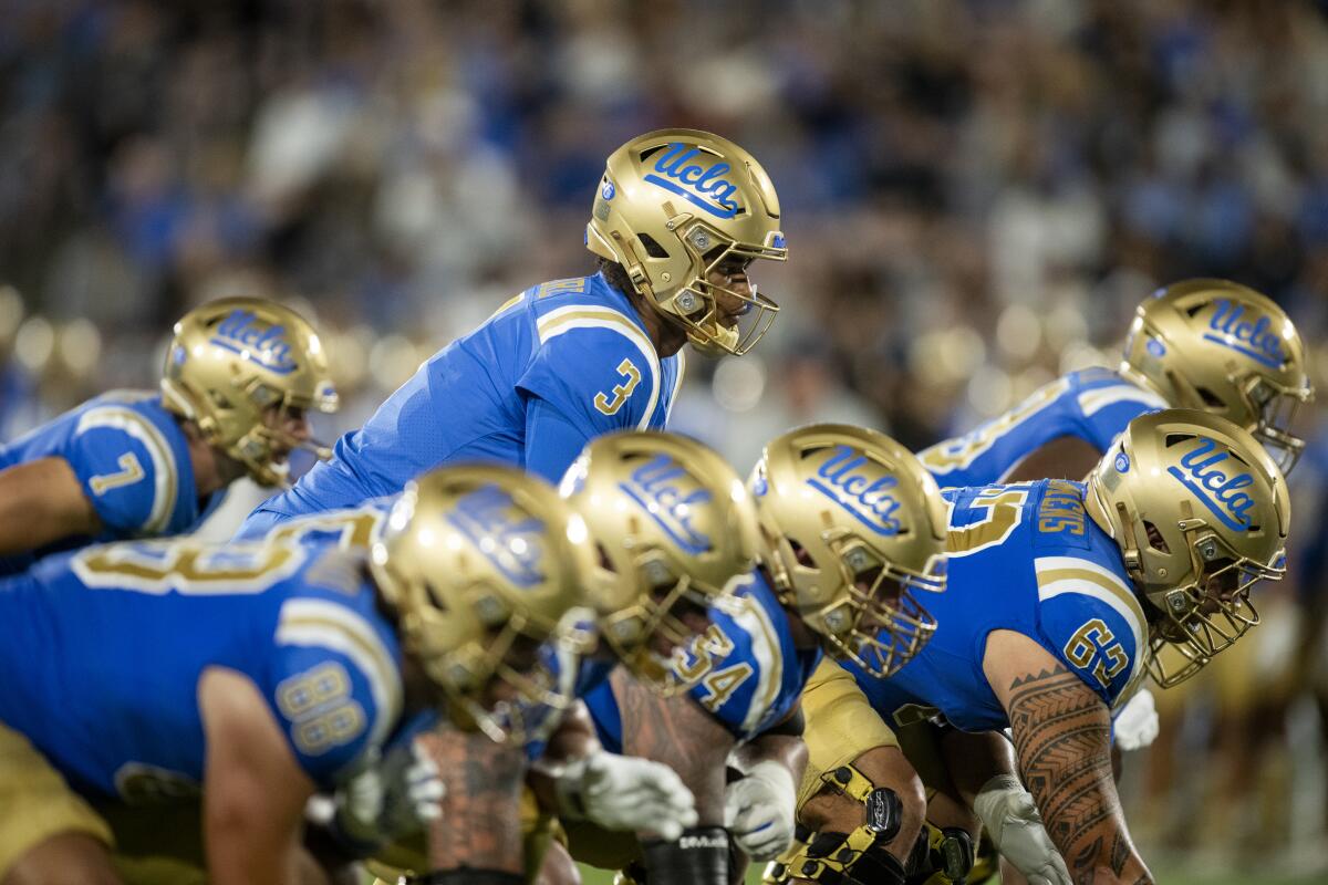 UCLA quarterback Dante Moore lines up behind his offensive line 