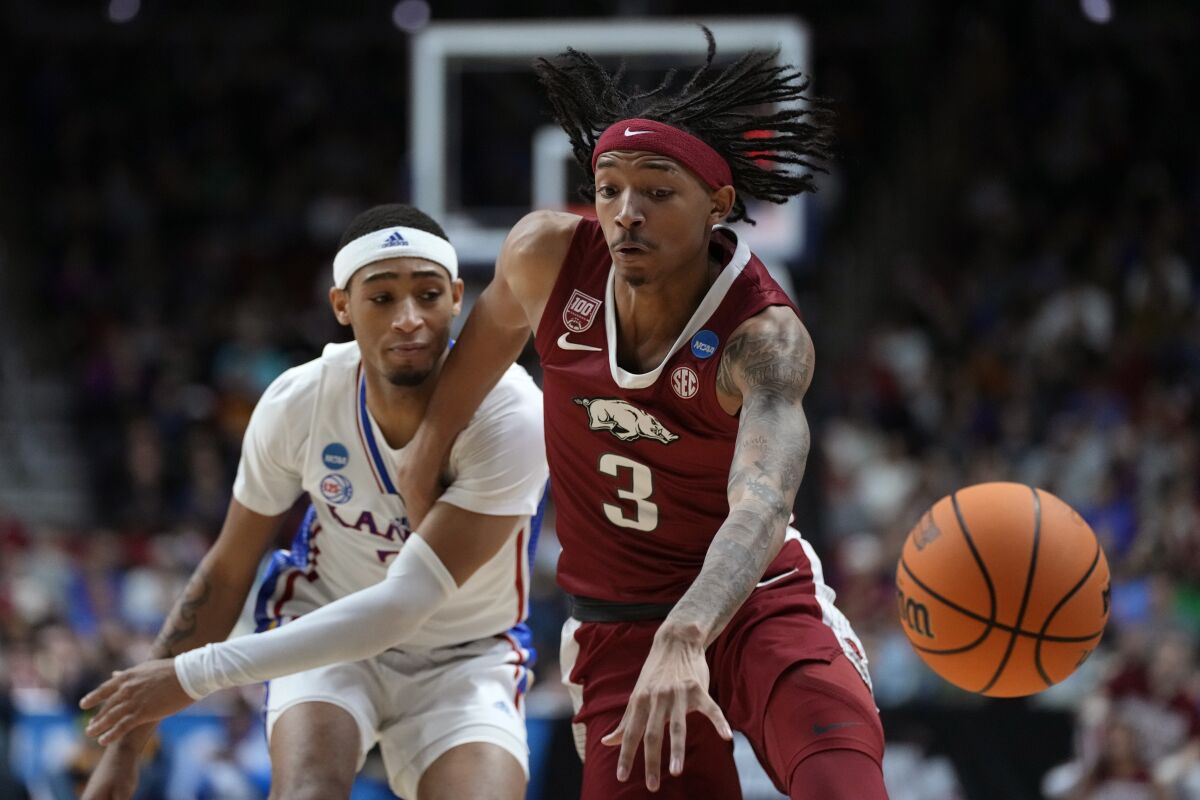 Arkansas guard Nick Smith Jr. loses control of the ball as he drives past Kansas guard Dajuan Harris Jr., left, in the first half of a second-round college basketball game in the NCAA Tournament, Saturday, March 18, 2023, in Des Moines, Iowa. (AP Photo/Charlie Neibergall)