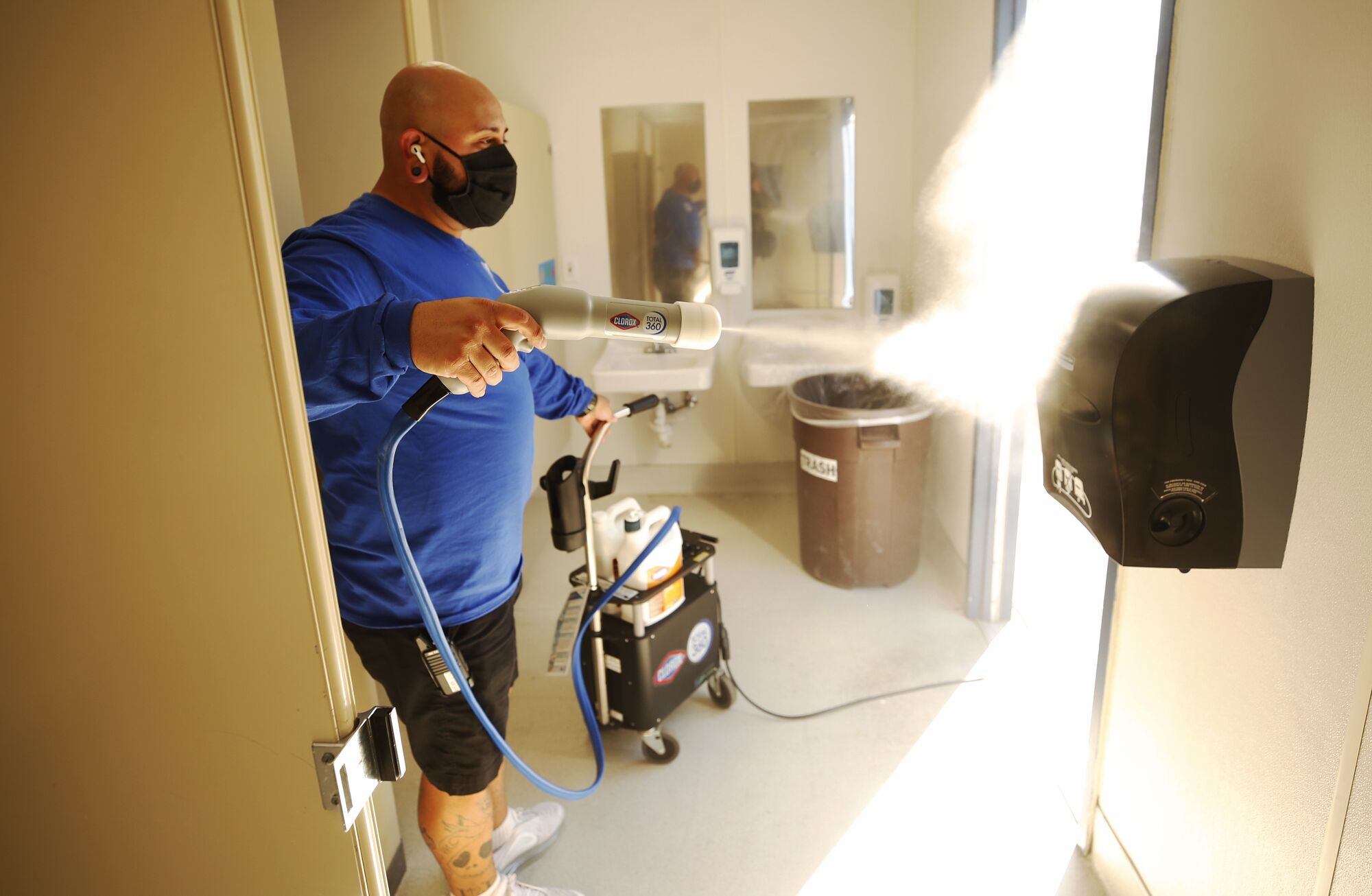 David Contreras uses a spray gun in a bathroom at the school.